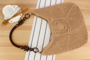 Borsa a tracolla intrecciata a mano con manico in perline di legno per vacanze al mare.