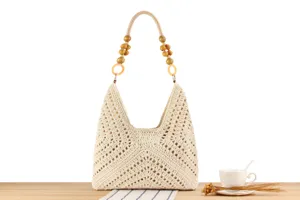 Close-up detail of beige cotton rope woven shoulder bag with wooden bead handle.