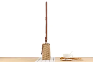 Detailed side view of handmade woven crossbody bag featuring brown leather strap and box.