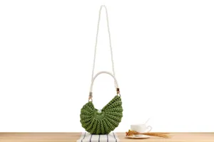 Handmade green crochet shell shoulder bag with elegant white pearl strap and woven handle.