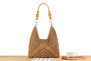 Detail view of the handmade crochet shoulder bag featuring unique wooden bead handle decor.