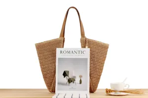 Straw woven tote bag detailed view, natural paper straw material with brown leather handles.
