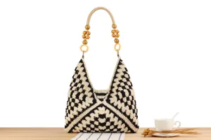Close-up detail of the black and white crochet shoulder bag showcasing wooden bead handle.
