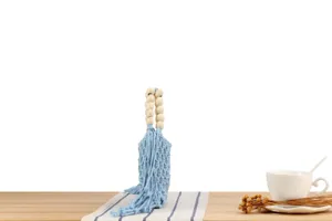 Handcrafted blue macrame woven bag detail with wooden bead handle and stylish fringe tassels.