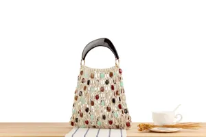 Vue detaillee du sac a main tisse en macrame avec des perles colorees et poignee en resine.