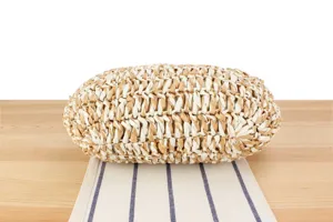 Close-up detail shot of the handcrafted woven straw bag, showcasing the unique two-tone texture.