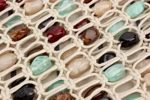 Gros plan détaillé du sac macramé tissé avec des perles de pierre et cordon en filet.
