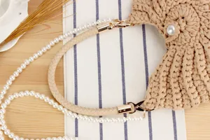 Handcrafted beige woven bag detail shot featuring pearl accents and dual straps for women.