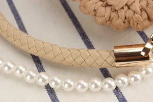 Handmade woven crossbody handbag detail featuring stylish leather strap and pearl decor.