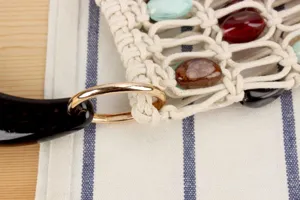 Gros plan detail du sac a main tendance en macrame fait main avec perles colorees anneau metal.