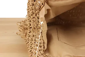 Detailed close-up view of the stylish straw woven handbag interior and gold metal chain strap.