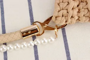 Crochet bag detail showing gold tone metal hardware, braided strap and elegant pearl chain.