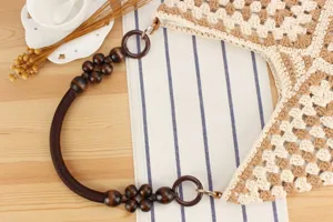 Detailed shot of a chic crochet shoulder bag with wooden bead handle and stylish knit design.