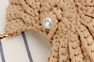 Handmade crochet knit bag detail close-up, beige woven casual fashion women handbag