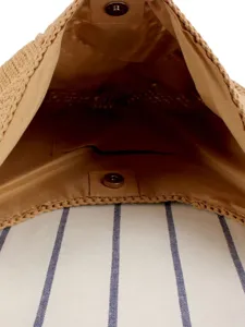 Dettaglio interno della borsa a tracolla intrecciata a mano, borsa di paglia con fodera e snap.