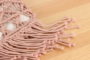 Close-up detail of handmade woven cotton bag with cute tassel fringe texture design.