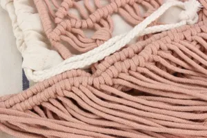 Handcrafted macrame woven bag detail shot, featuring delicate pink and white cotton rope texture.