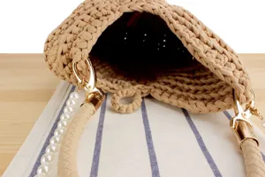 Handmade beige crochet women's handbag detail with pearl strap and golden hardware