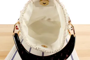 Détail intérieur de sac fourre-tout tissé avec compartiment et poignée écaille.