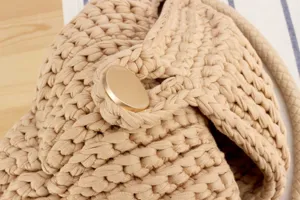 Handmade chunky knit woven bag detail showcasing exquisite texture and elegant metal button clasp.