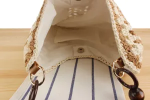 Detailed view of the woven cotton rope shoulder bag showing interior lining and wooden ring handle.