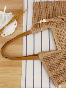 Stylish woven straw tote bag with leather handles and tassel for women daily casual vacation.