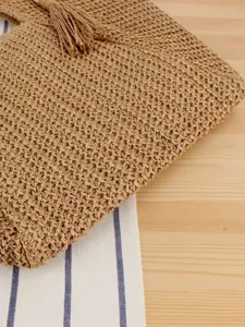 Woven straw handbag for women, casual summer beach tote bag with stylish tassel decoration.
