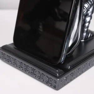 Vista de detalle del soporte de teléfono de resina, textura de base negra y soporte para smartphone.