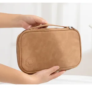 Detail view of brown leather travel jewelry organizer bag with portable handle and zipper.