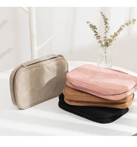 Close-up of portable leather travel jewelry storage pouches in multiple elegant colors.