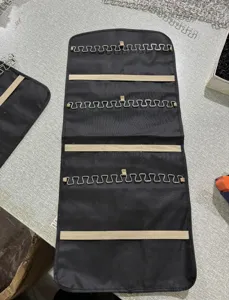Organizador de joyas colgante con ganchos metálicos y bandas elásticas para pendientes.