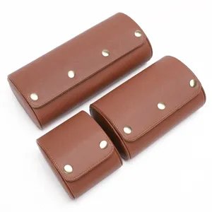 Detailweergave van bruine lederen horlogedozen met drukknoppen voor veilige opberging.