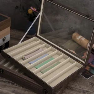 Caja de almacenamiento de madera para correas de reloj con ranuras de terciopelo.