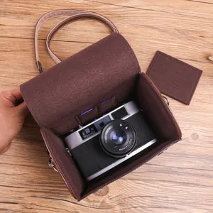 Vintage bruine lederen cameratas met zachte voering en verdeler voor spiegelloze camera's.