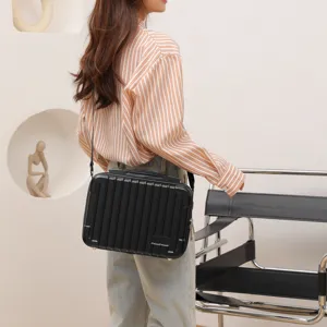 Borsa a tracolla rigida nera, design da mini valigia per custodire visori VR e piccoli oggetti.