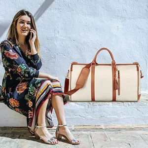 Foto de detalle lifestyle de una gran bolsa de viaje de cuero PU con asas y borlas marrones.