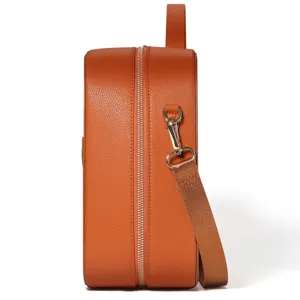 Vista laterale dettagliata di borsa custodia in pelle marrone arancione con cerniera e tracolla.