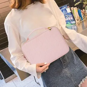 Pink quilted watch band organizer bag, detailed view of accessory storage and portable handle.