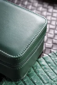 Detailed view of the dark green leather watch box showing premium stitching and texture.