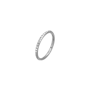 Close-up detail of titanium piercing ring with textured pyramid design for stylish ear cartilage.