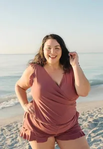 Beach detail view of a plus-size V-neck ruffle wrap swimsuit with built-in bra support.