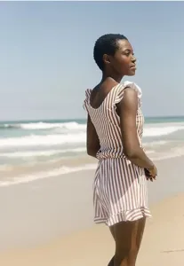 Detailed view of women's trendy brown and white striped beach swimsuit with cute ruffles.