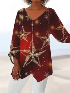 Detailed view of women's long sleeve V-neck top with gold glitter star and snowflake print.