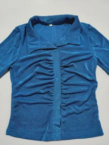 Sexy slim-fit long sleeve button-down collared blouse with ruched front detail in blue.