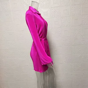 Detail view of vibrant pink pleated long sleeve shirt dress with matching belt for women.