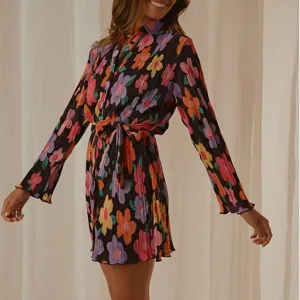Detailed shot of women long sleeve floral printed pleated shirt dress featuring waist tie.