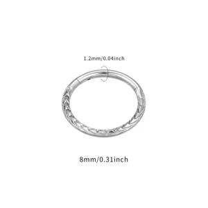 Nahaufnahme Detail eines Titan Scharnier Piercingrings mit geschnitztem Muster und Maß.