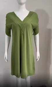 Detail shot of the green V-neck pleated batwing sleeve dress, showcasing collar design.