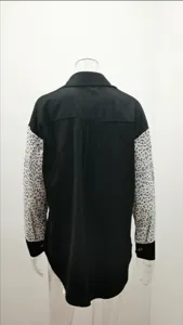 Detailed back view of women's black corduroy long sleeve shirt with leopard print sleeves.