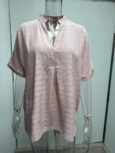 Detail view of a light pink short sleeve V-neck blouse with textured fabric and loose fit.